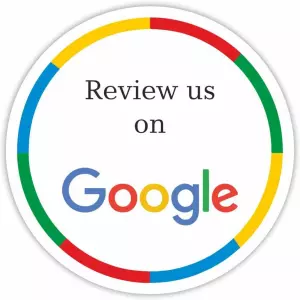Circular badge with colorful segments in red, yellow, green, and blue around the edge. Inside, "Review us on" is written at the top, followed by the Google logo, which consists of "Google" in colored letters (blue, red, yellow, and green).