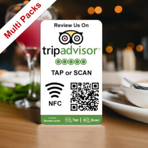 A tabletop display card with the TripAdvisor logo reads: "TripAdvisor Tap or Scan Smart Review Cards Packs - Free Delivery" alongside a QR code and NFC symbol. A red label in the corner says "Multi Packs." The card is placed on a table set with dishes and a drink, blurred background visible.