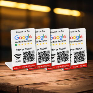 Four table cards promoting 2 Google Tap or Scan Stands - FREE Delivery are placed on a wooden surface. Each card, doubling as Google tap or scan stands, displays a QR code, NFC symbol, and instruction to "TAP or SCAN." They feature the Google logo and a star rating section. The background is blurred with warm lighting.