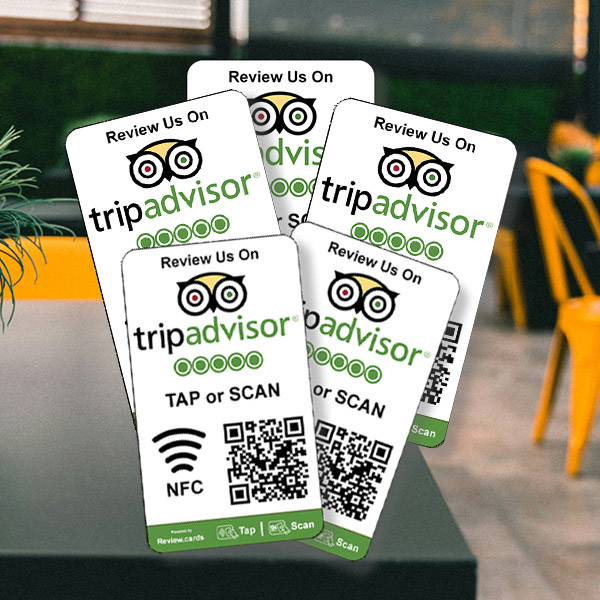 Five TripAdvisor Tap or Scan Smart Review Cards adorn a table in a contemporary café setting. Each card encourages patrons to "Review Us On TripAdvisor" featuring the iconic owl logo. Clear instructions are provided to tap or scan via NFC or QR code for easy reviews, with the prompt "TAP or SCAN" prominently displayed.