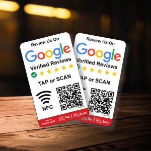 Two 2 Google Smart Review Cards are displayed on a wooden surface. Each card features a five-star rating, with options to tap or scan using NFC or a QR code for leaving a review. The background is slightly blurred, emphasizing the cards.